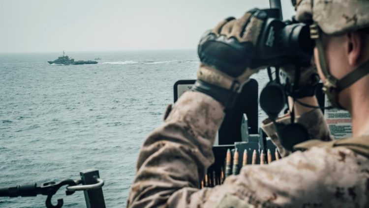 أحد أفراد المارينز الأميركي على متن سفينة حربية قرب مضيق هرمز (رويترز)