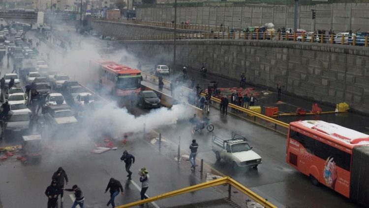شرطة مكافحة الشغب في إيران تحاول تفريق متظاهرين يحتجون على ارتفاع أسعار الوقود (رويترز)