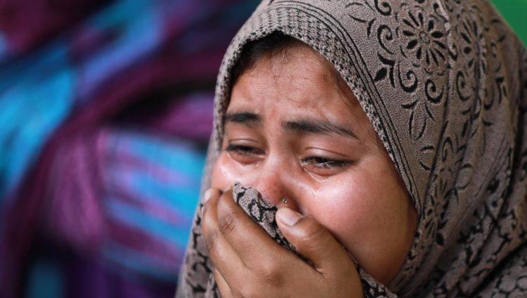 المأساة على وجه مسلمة اضطرت لهجر منزلها وأسرتها (رويترز)